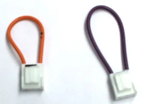 Zwei elektrische Verbindungskabel mit weißen Anschlusssteckern, eines orange und eines lila, geeignet für die Verwendung in Daikin-Systemen.